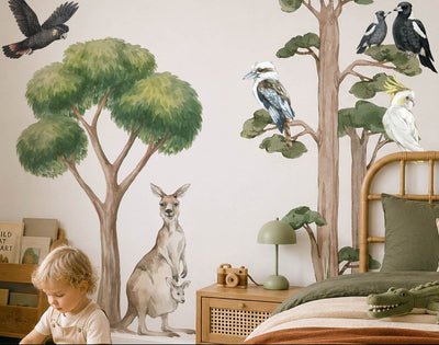 Child playing with toys in a room with tree and animal wall decals.