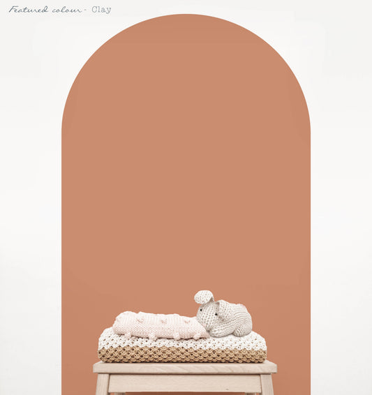 Clay arch wall decal in a warm earthy nursery with natural timber furniture
