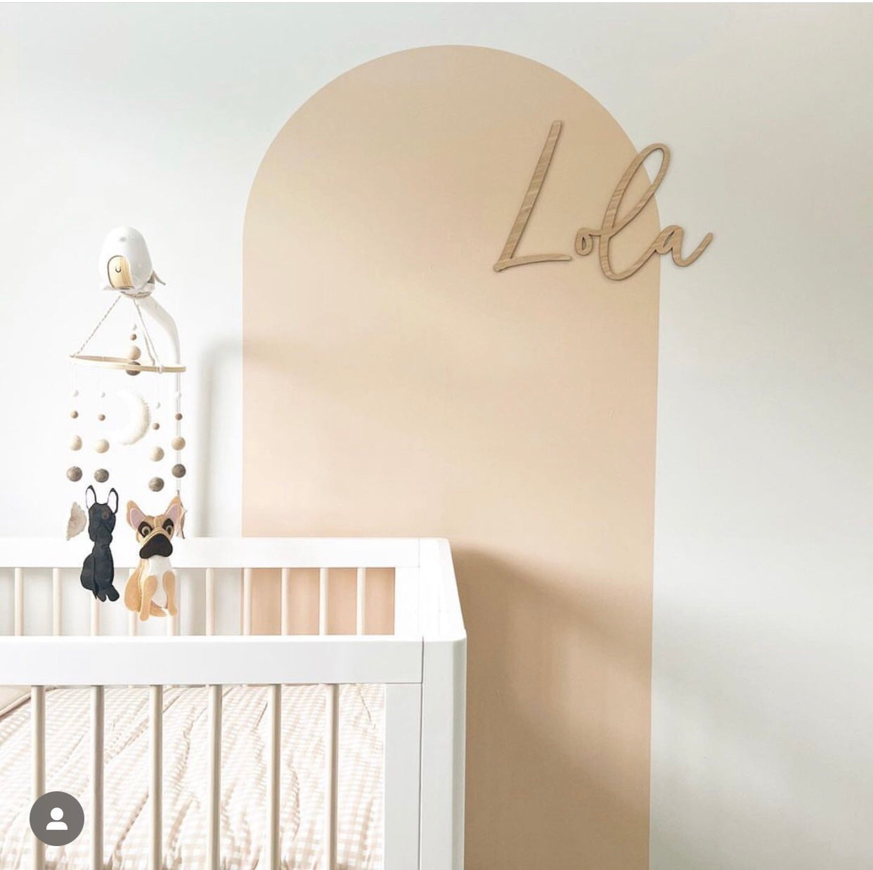 Soft peach arch wall decal creating a warm feature wall in a modern nursery