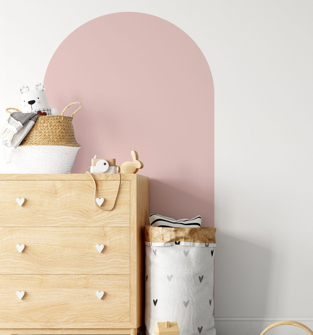 Blush pink arch wall decal creating a warm feature wall in a modern nursery