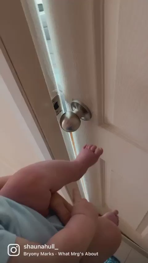 Load video: Baby opening door to nursery with foot, featuring fable and fawns baby blue arch decal and hot air balloon decals
